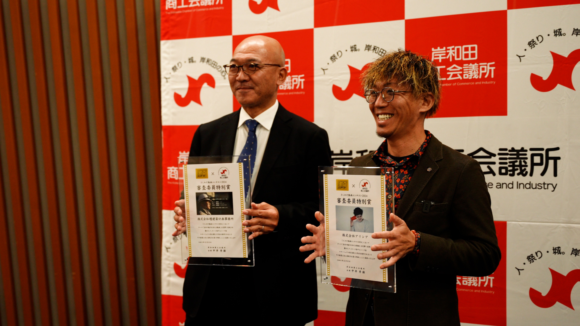 写真：大阪府岸和田市岸和田商工会議所主催の動画コンテスト授業式で審査委員特別賞を受賞した株式会社アリシア代表岡野稔功（右）と壇建築計画事務所の北野健太郎（左）